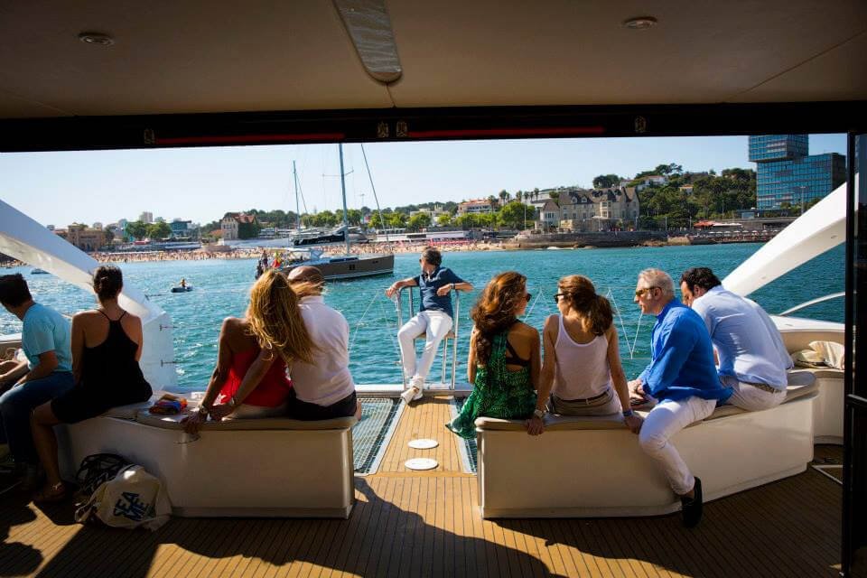 Grupo de pessoas num barco a desfrutar da Baía de Cascais