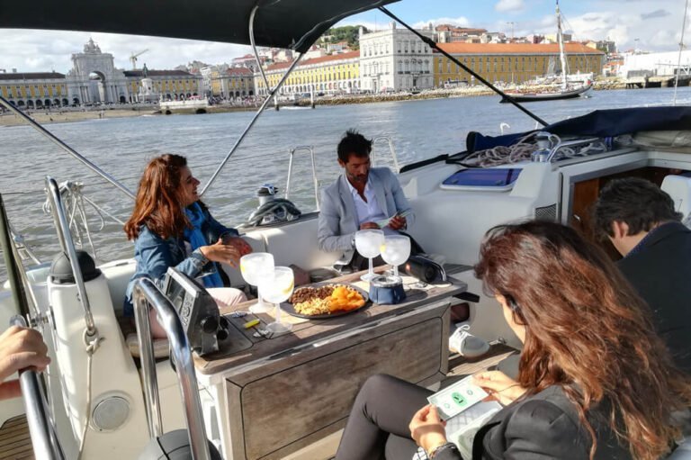 Pessoas num veleiro a ver a Praça do Comércio e Castelo de S. Jorge
