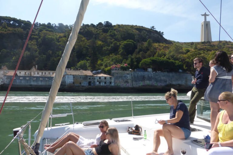 Pessoas a desfrutar de um dia sol a bordo de um catamaran em Lisboa