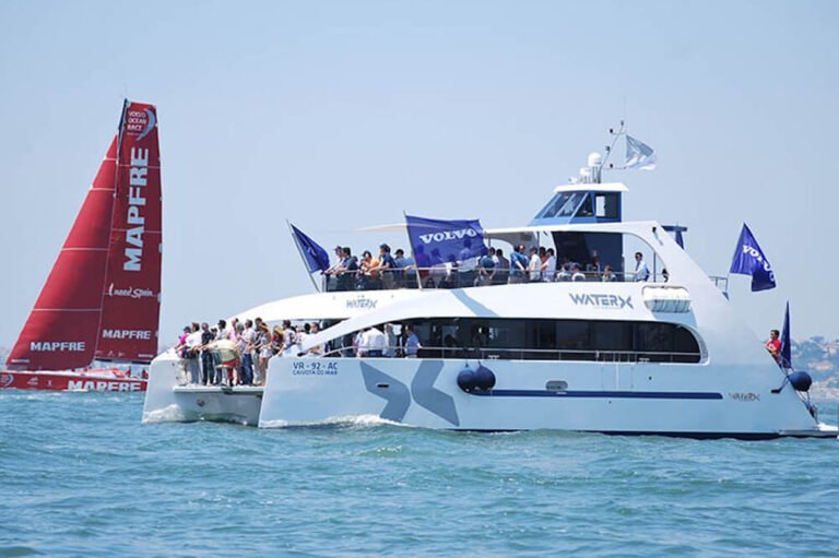 Pessoas a bordo de um catamaran a assistir à regata Volvo Ocean Race