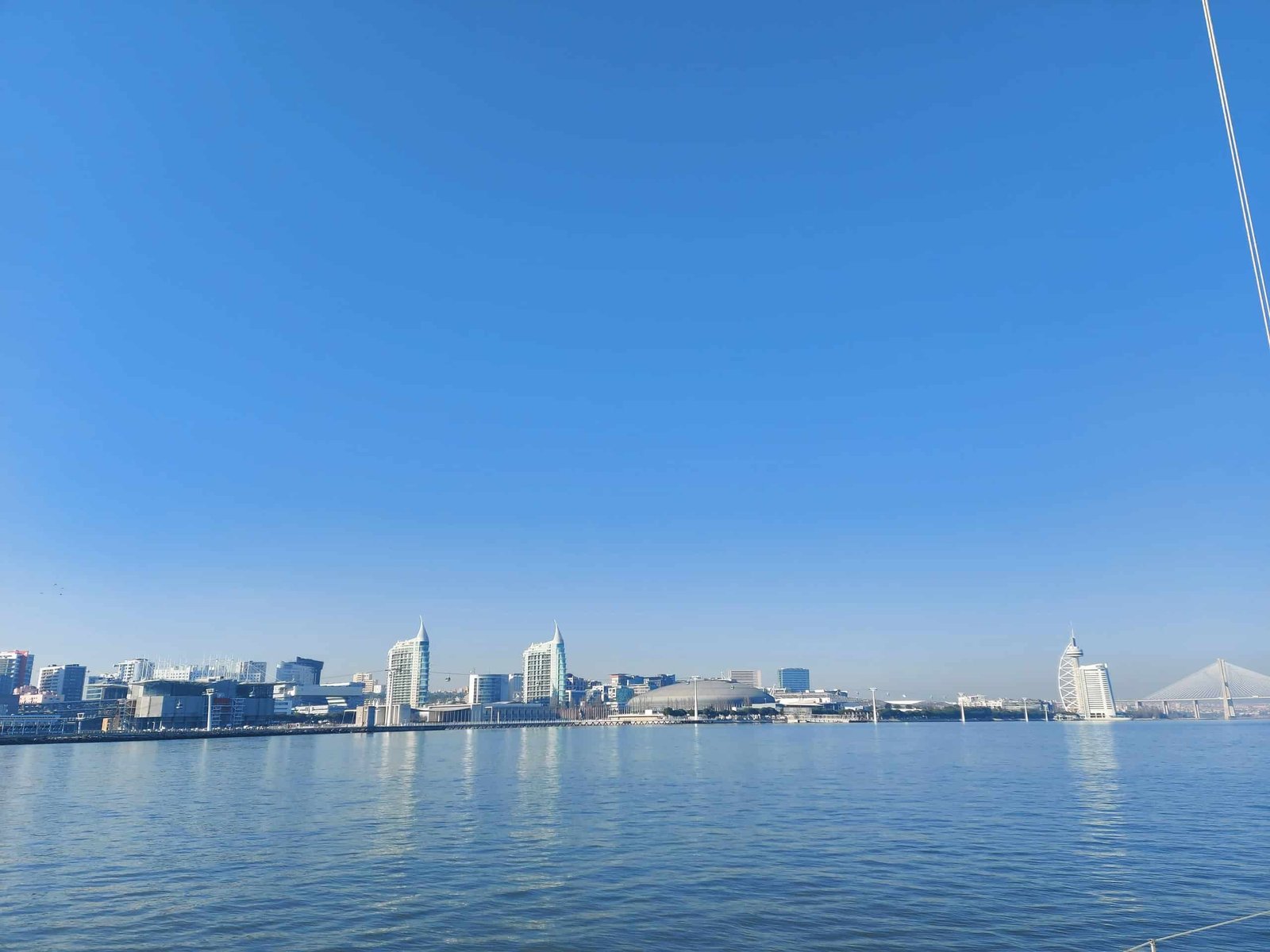 Vista do Parque das nações desde o Rio. Identificam-se a Torre da Vasco da Gama, a ponte Vasco da Gama, o Pavilhão atlântico e o Oceanário