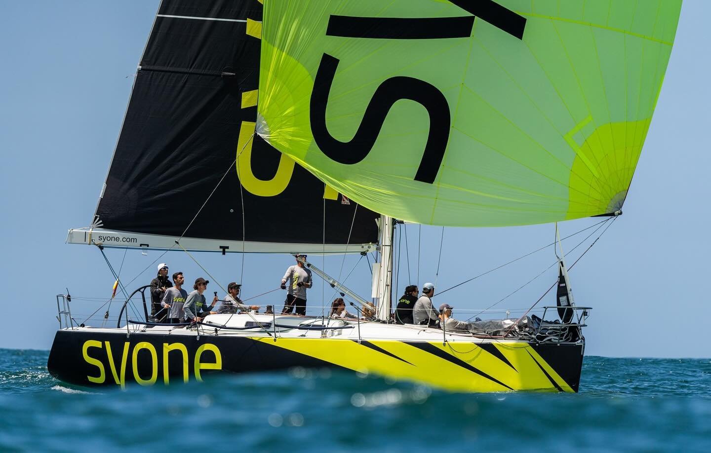 O barco e a equipa durante um treino, mostrando o design único da vela